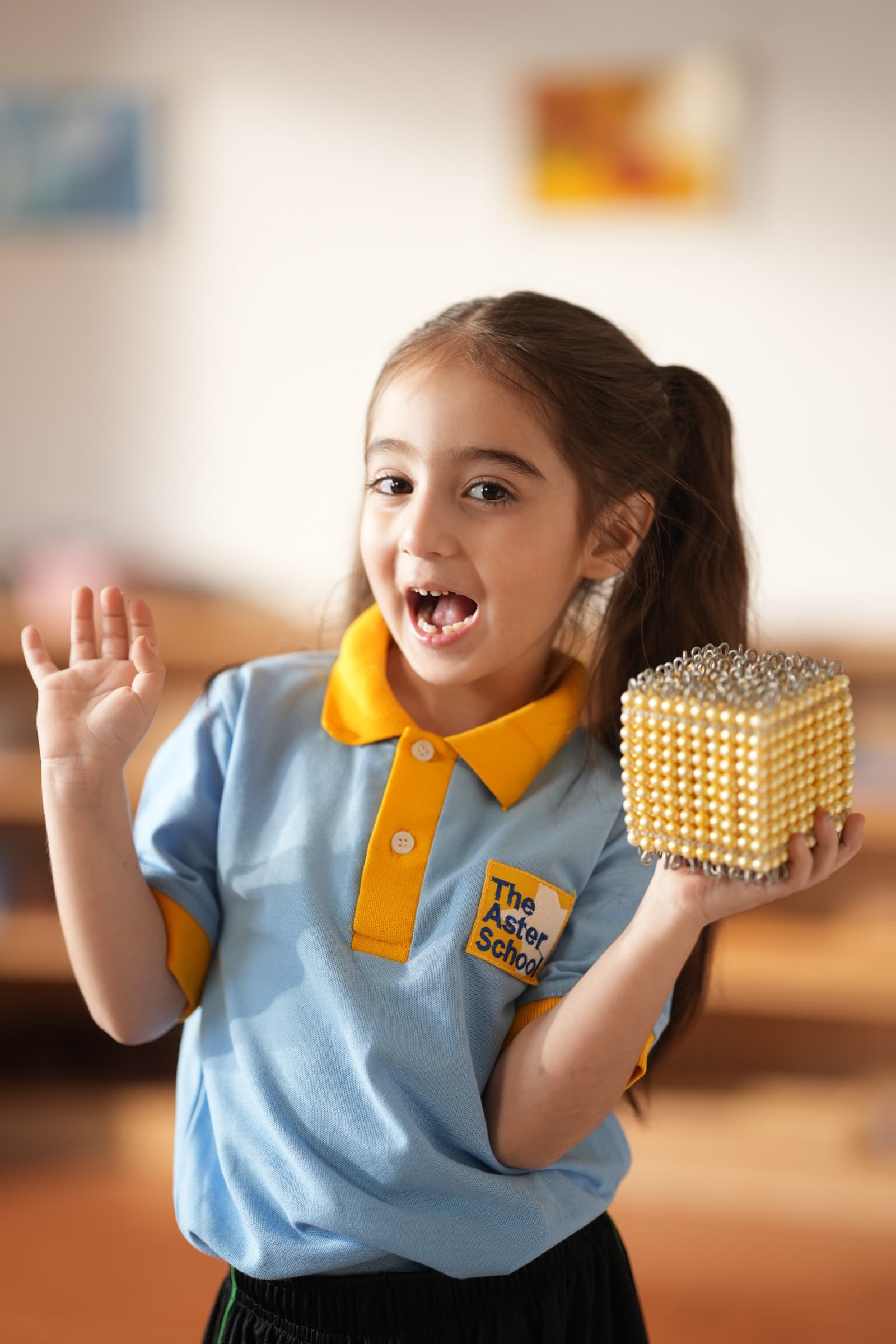 A child delighting in a Montessori golden bead cube