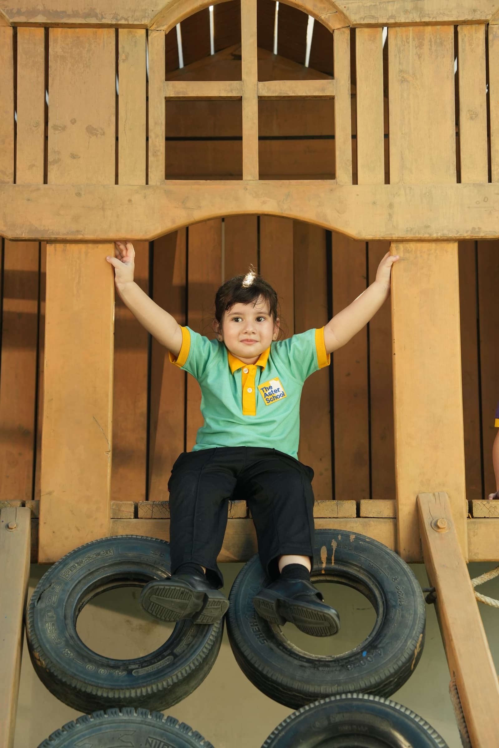 A child reaching up on the wooden play structure