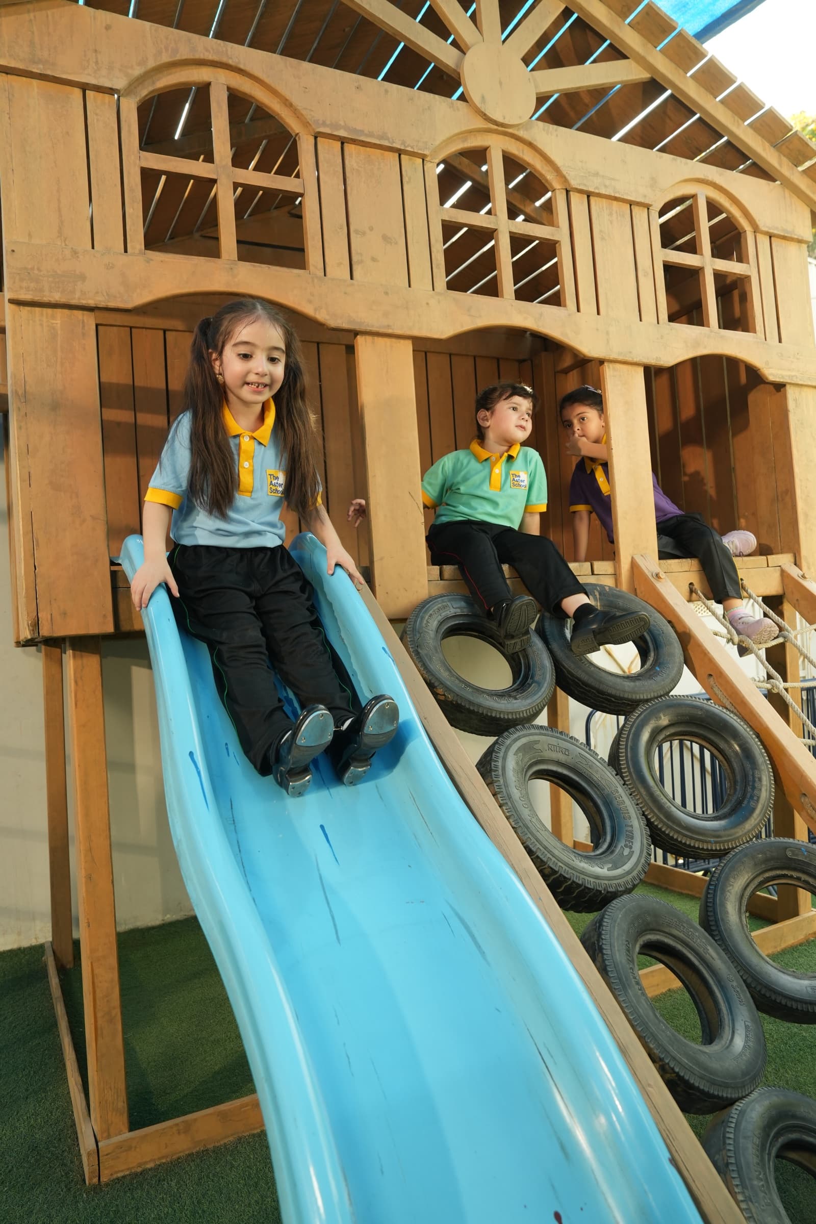 Children playing on the slide in the outdoor play area