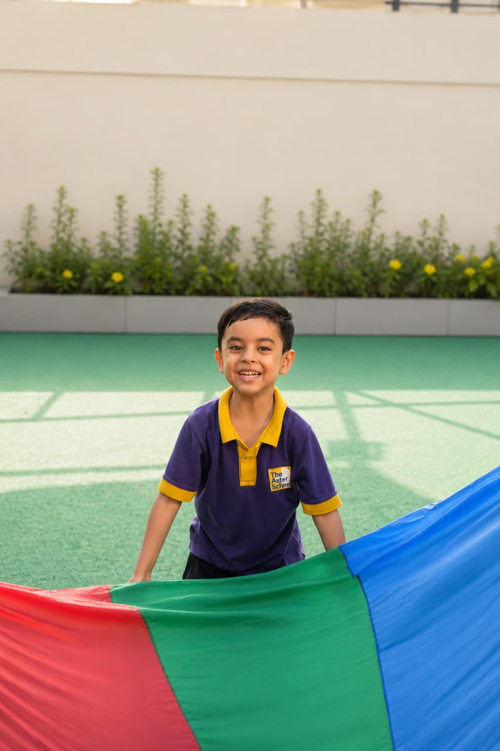 A smiling child playing with a parachute outdoors